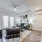 Living room at FLATZ 520 has black couch, chair, coffee table, art, TV stand, fan, AC, French doors, and hardwood floor.
