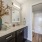 Luxury bathroom at FLATZ 520 features double-sink vanity, mirror, vase, folded towels, bathtub, and shower area.