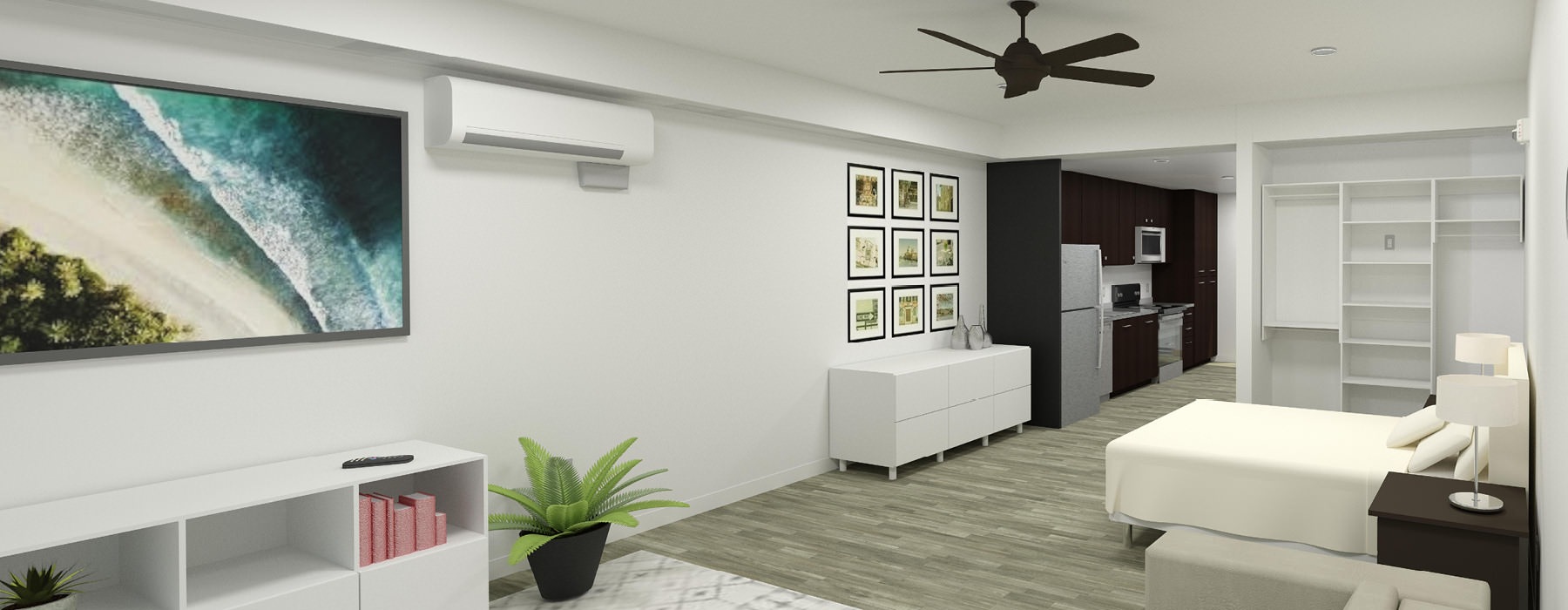 interior of spacious, open studio apartment with a bed, wall mounted TV, book case, open closet area, with the kitchen in the background